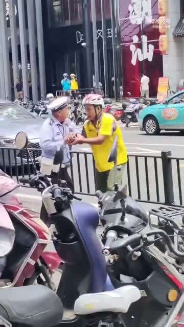 7月21日(发布) 上海。交警先是拿着外卖小哥的手机不还，接着又上前拔掉了小哥电动车上的钥匙。